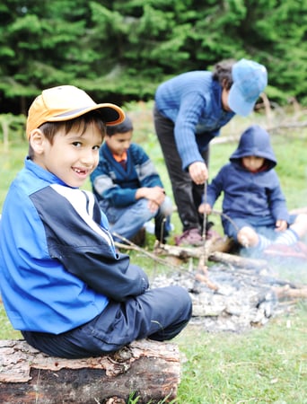 Barbecue in nature, group of children  preparing sausages on fire